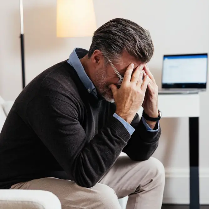 Erschöpfter Mann hält sich die Hände vors Gesicht – Burnout und chronischer Stress als Auslöser von oxidativem Zellstress, unterstützend behandelt mit Sanopal Forte Aktive Zellkur