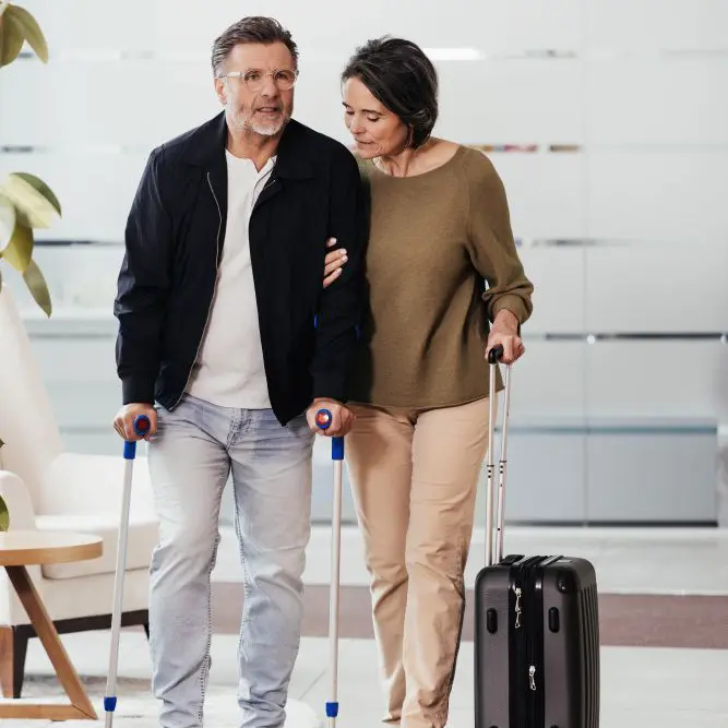 Mann mit Unterarmkrücken wird von Frau gestützt – Rehabilitation nach Operation, Unterstützung der Zellregeneration mit Sanopal Forte Aktive Zellkur